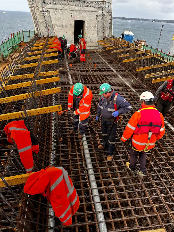 Equipo de obra trabajando sobre la armadura de la pila central del Puente Chacao